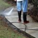 Worker pressure washing sidewalk