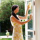 Smiling woman cleaning glass doors