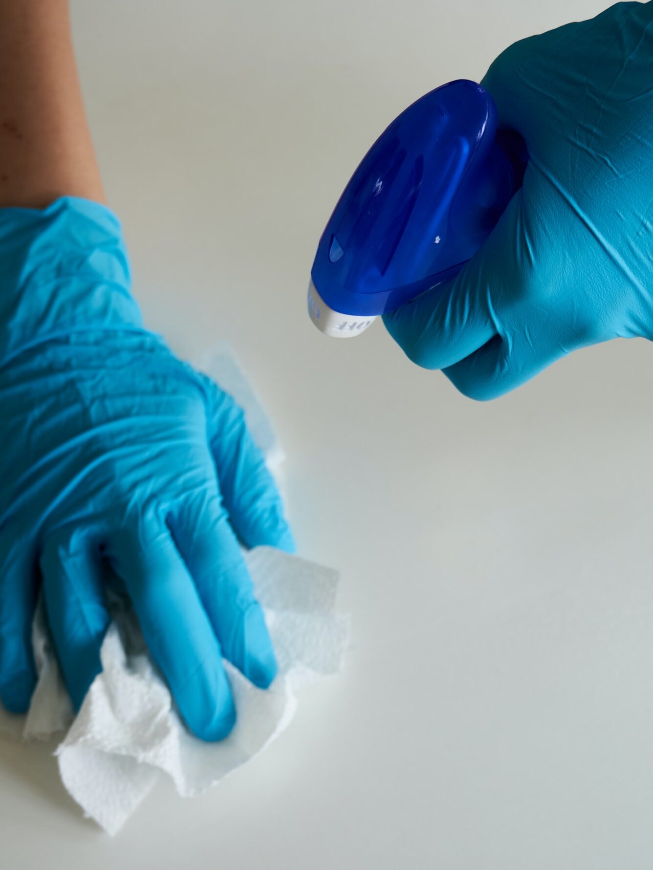 Diamond Cleaning image of a pair of hands cleaning a surface with spray and tissue.